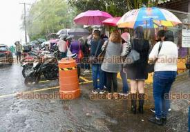 Xalapa, Ver., 8 de diciembre de 2025.- Bajo el agua, este lunes docentes de la Capital, Coatepec y Veracruz Puerto hacen fila afuera de la SEV para recibir nueva tarjeta bancaria con la que se implementa la Nmina nica. Se dijeron molestos por esta situacin.