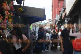 Xalapa, Ver., 20 de diciembre de 2025.- Transeúntes prefieren caminar sobre la calle Clavijero para evitar la multitud que generan los puestos ambulantes colocados a orilla de la banqueta.