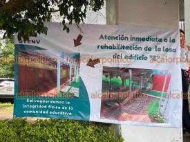 Xalapa, Ver., 9 de julio de 2026.- Estudiantes y docentes colocaron lonas para exigir la reparación urgente de la losa del Edificio “E” de la Escuela Normal Veracruzana. El espacio alberga al menos 10 salones de talleres.
